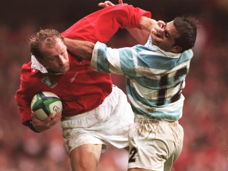 Gareth Thomas aplica un hand off sobre Lisandro Arbizu, en el choque entre los Pumas y Gales en el Mundial de 1999