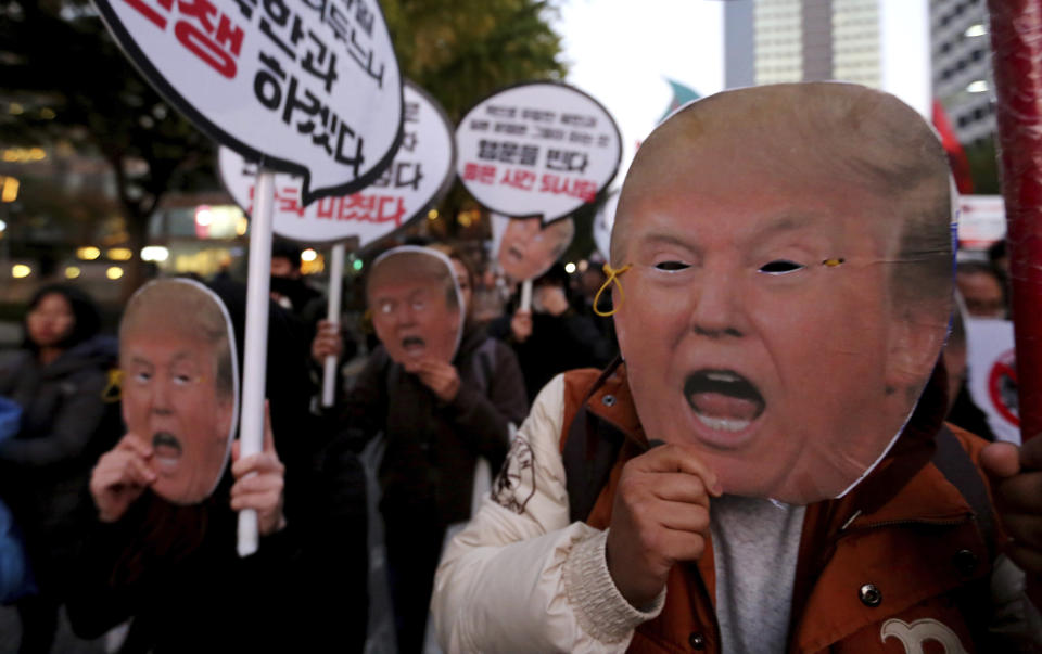 <p>Protesters wearing masks of President Donald Trump march toward the U.S. Embassy during a rally to oppose a planned his visit in Seoul, South Korea, Saturday, Nov. 4, 2017. The signs read ” Stop the War.” (Photo: Ahn Young-joon/AP) </p>
