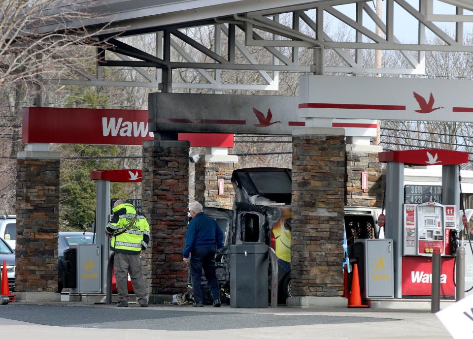 A burned plumbing company van sits under the gas awning at the Wawa on Route 34 in Wall Township, NJ, Tuesday, March 1, 2022.  The store and gas pumps remain closed after the fire.