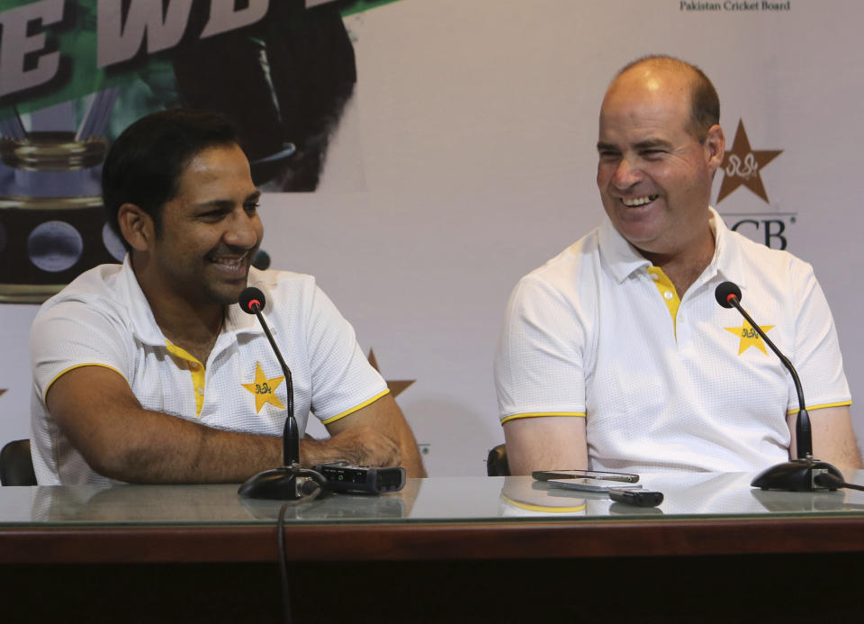 Pakistan's cricket team captain Sarfaraz Ahmed, left, gestures during a news conference with coach Mickey Arthur in Lahore, Pakistan, Monday, April 22, 2019. Ahmed likes that Pakistan is considered an underdog entering the World Cup beginning next month in England but insisted that despite the label, the 15-member squad is well prepared. (AP Photo/K.M. Chaudary)