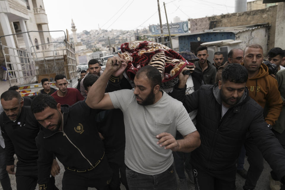 Mourners carry the body of Palestinian Fulla al-Masalmeh,15, during her funeral in the West Bank village of Beit Awwa, Tuesday, Nov. 15, 2022. The Palestinian Health Ministry says Israeli forces shot and killed a 15-year-old Palestinian girl during a pre-dawn raid in the occupied West Bank. The circumstances surrounding the death of the teenage girl in the city of Beitunia in the central West Bank, identified by Palestinian health officials as Fulla al-Masalmeh, were not fully clear. The Israeli military said soldiers opened fire on a vehicle that was accelerating toward them after they signaled for it to stop. The military said it was investigating, and declined to comment further. (AP Photo/Mahmoud Illean)