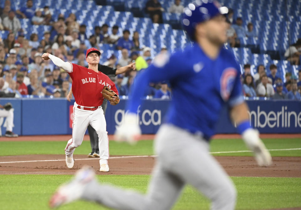 Toronto Blue Jays' third baseman Matt Chapman, left, throws to first base to put out Chicago Cubs Nick Madrigal, right, in first-inning baseball game action in Toronto, Monday, Aug. 29, 2022. (Jon Blacker/The Canadian Press via AP)