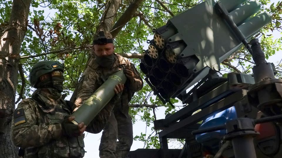 Ukrainian servicemen load shells into a RAK-SA-12 small multiple launch rocket system near the front line town of Bakhmut. - Sofiia Gatilova/Reuters