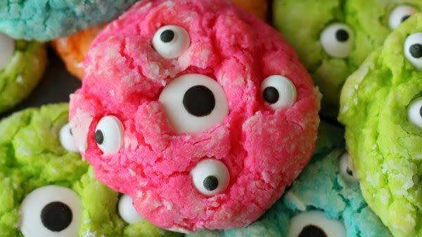 pink, green, and blue cookies with candy googly eyes baked for halloween activity
