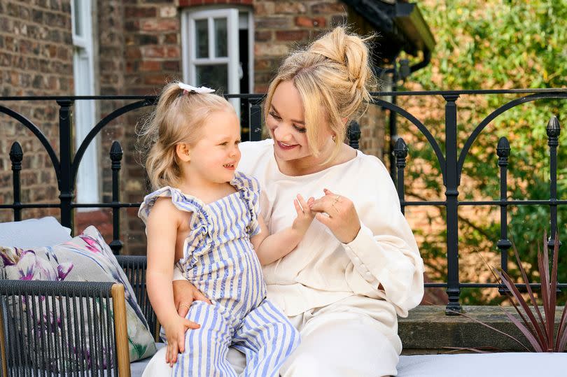 Kirsty-Leigh Porter poses sitting down with her daughter Nala