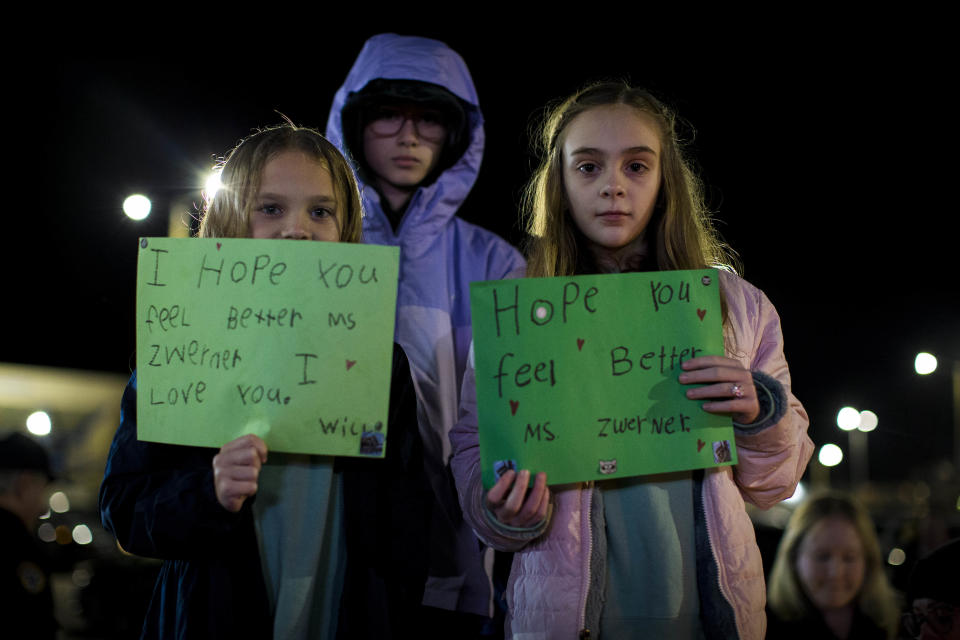 Willow Crawford, left, and her older sister Ava, right, join friend Kaylynn Vestre, center, in expressing their support for Richneck Elementary School first-grade teacher Abby Zwerner during a candlelight vigil in her honor at the School Administration Building in Newport News, Va., Monday, Jan. 9, 2023. Zwerner was shot and wounded by a 6-year-old student while teaching class on Friday, Jan. 6. (AP Photo/John C. Clark)