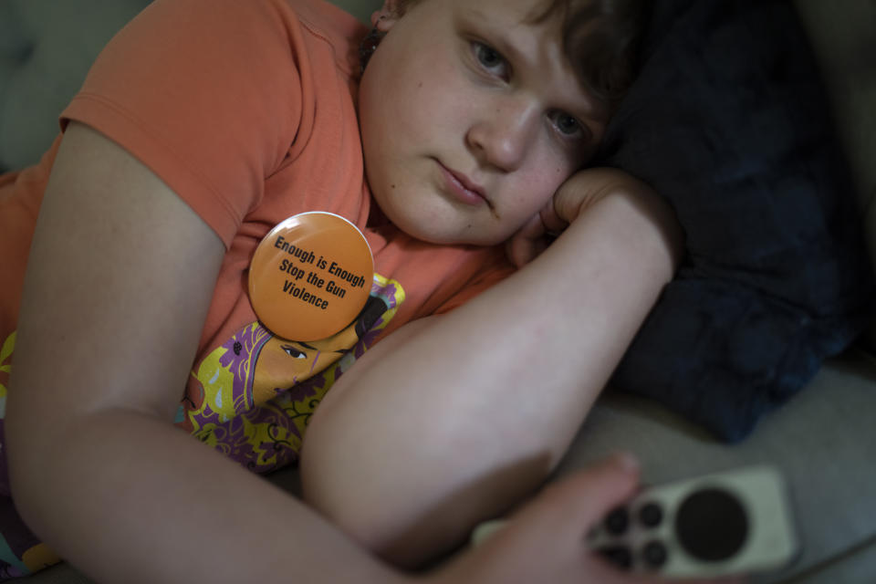 Sylvia Holm, 11, watches television after she attended a rally against gun violence with her family in Louisville, Ky., Saturday, June 3, 2023. In 2017, Sylvia started kindergarten. At the dinner table that fall, she announced that her class had learned a new drill. First her teacher locked the classroom door and turned off all the lights. Then she instructed the five-year-olds to stay very quiet, so the “bad person” wouldn’t find them. (AP Photo/David Goldman)