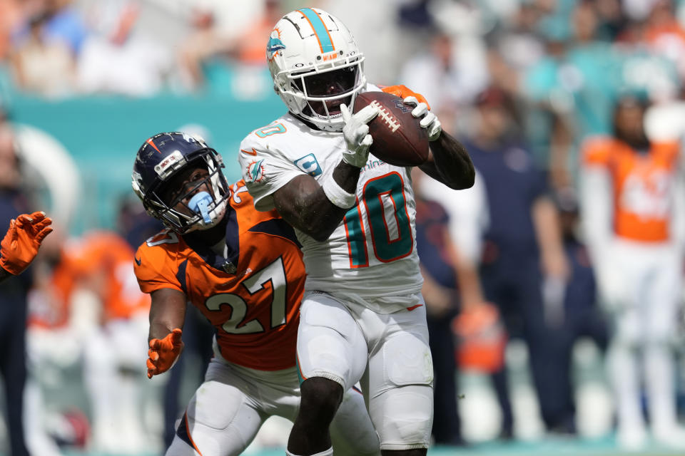 Miami Dolphins wide receiver Tyreek Hill (10) grabs a pass over Denver Broncos cornerback Damarri Mathis (27) during the second half of an NFL football game, Sunday, Sept. 24, 2023, in Miami Gardens, Fla. (AP Photo/Rebecca Blackwell)