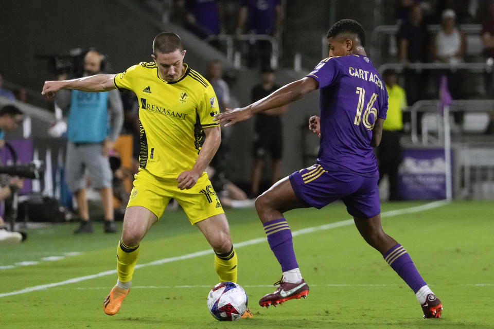 Nashville SC midfielder Alex Muyl (19) tries to push the ball past Orlando City midfielder Wilder Cartagena (16) during the first half of an MLS playoff soccer match, Monday, Oct. 30, 2023, in Orlando, Fla. (AP Photo/John Raoux)