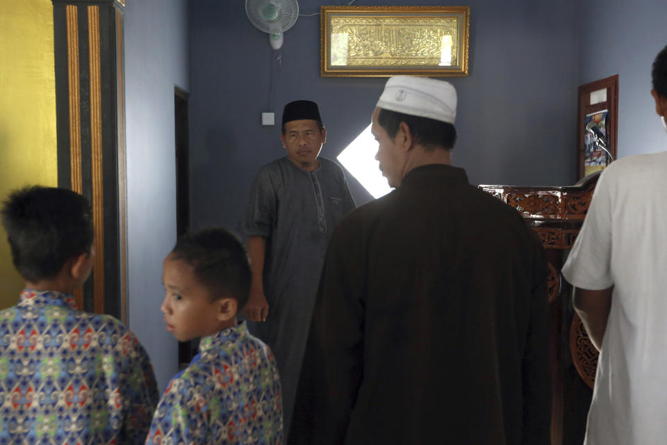 Ali Fauzi, center, prepares to pray at a mosque in Tenggulun, East Java, Indonesia, on Saturday, April 27, 2019. Three of Fauzi's brothers helped orchestrate the 2002 Bali bombings, and Fauzi was once the chief bombmaking instructor for Jemaah Islamiyah, the Islamic militant group behind the Bali attack. He now works with terrorism victims on peacebuilding efforts throughout Indonesia. (AP Photo/Tatan Syuflana)