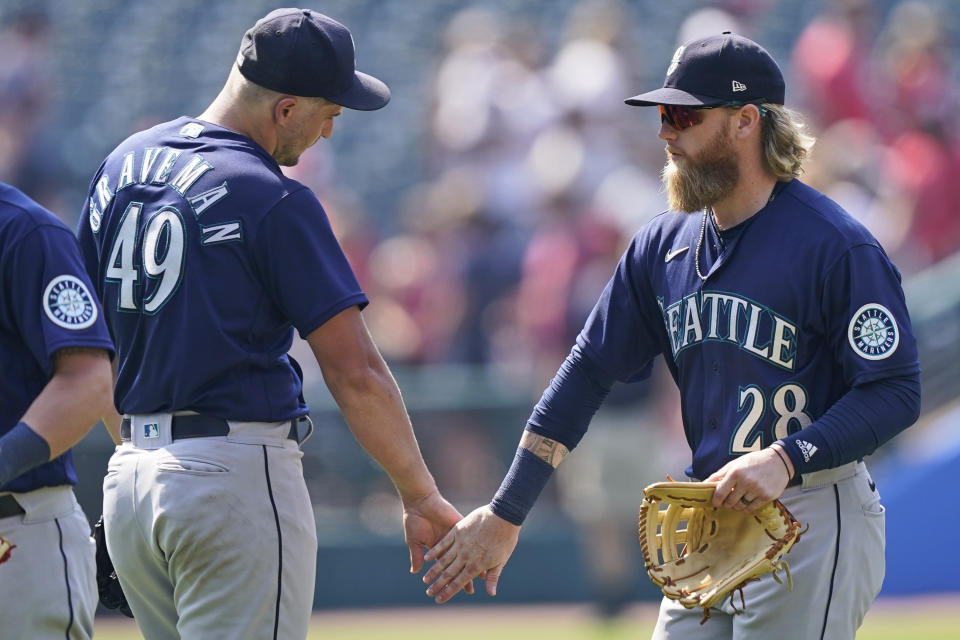 Seattle Mariners' Jake Fraley (28) and Kendall Graveman (49) celebrate after they defeated the Cleveland Indians in a baseball game, Sunday, June 13, 2021, in Cleveland. (AP Photo/Tony Dejak)