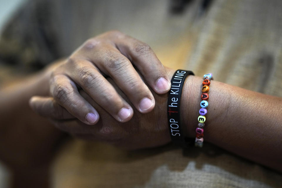 Catholic priest Rev. Flaviano "Flavie" Villanueva touches his rubber bracelet with a sign "Stop the Killing" during an interview with the Associated Press in Manila, Philippines on June 27, 2022. Villanueva said the widespread killings during the anti-drug campaign have left many orphans, deprived families of breadwinners and sparked other complex problems that Philippine President Rodrigo Duterte was leaving behind. (AP Photo/Aaron Favila)