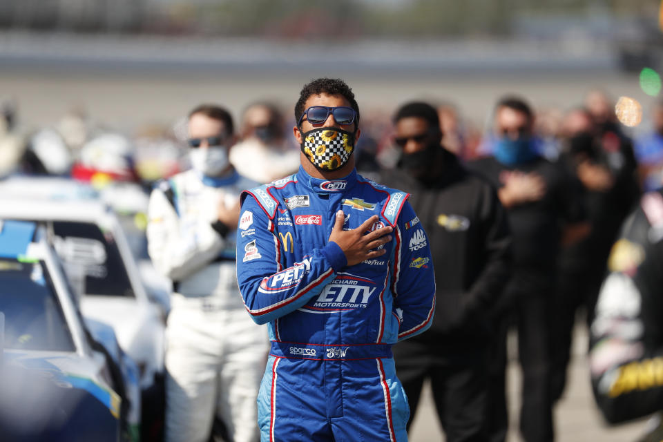 Bubba Wallace stands for the national anthem before a NASCAR Cup Series auto race at Michigan International Speedway in Brooklyn, Mich., Saturday, Aug. 8, 2020. (AP Photo/Paul Sancya)