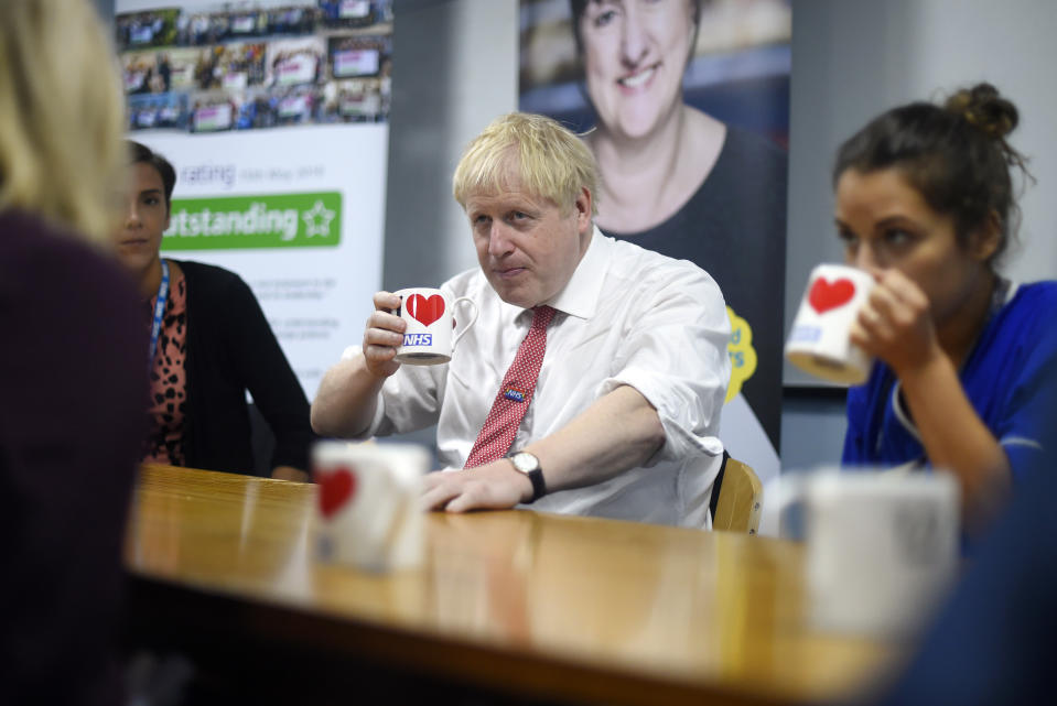 Britain's Prime Minister Boris Johnson speaks to mental health professionals as he visits Watford General hospital, England, Monday Oct. 7, 2019. The UK government has pledged billions for new hospital projects across England under plans devised up by Health Secretary Matt Hancock. (Peter Summers/Pool via AP)