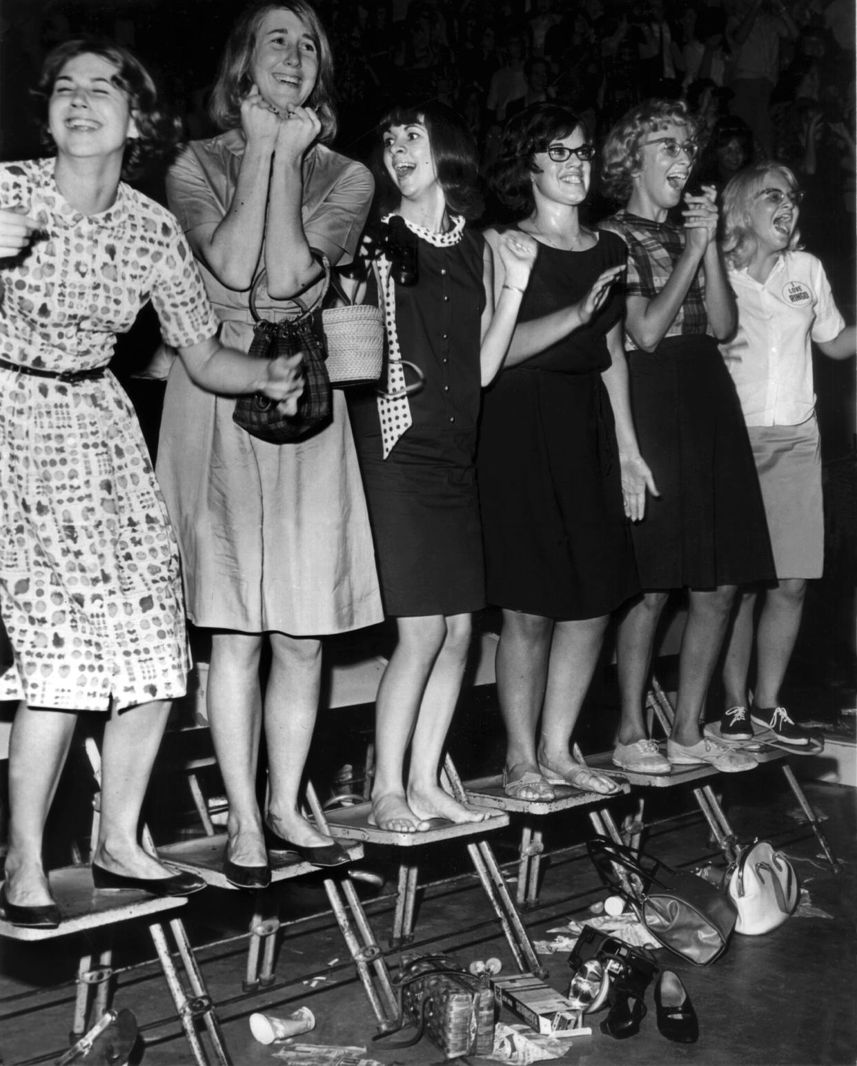 Fans of The Beatles stand on their chairs during the group’s performance at Cincinnati Gardens in August 1964.