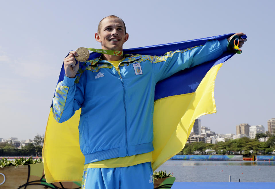 FILE - Ukraine's Yuri Cheban celebrates his gold in the men's canoe single 200m final during the 2016 Summer Olympics in Rio de Janeiro, on Aug. 18, 2016. Cheban, one of Ukraine's most decorated Olympians, told The Associated Press in an email exchange Wednesday, Nov. 30, 2022, that he is auctioning his medals — two golds and a bronze — in hopes of raising a six-figure donation to contribute to the war effort in his native land. (AP Photo/Matt York, File)