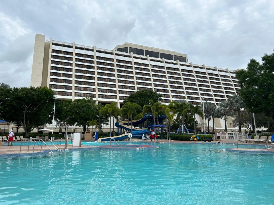 blue pool in front of white hotel building