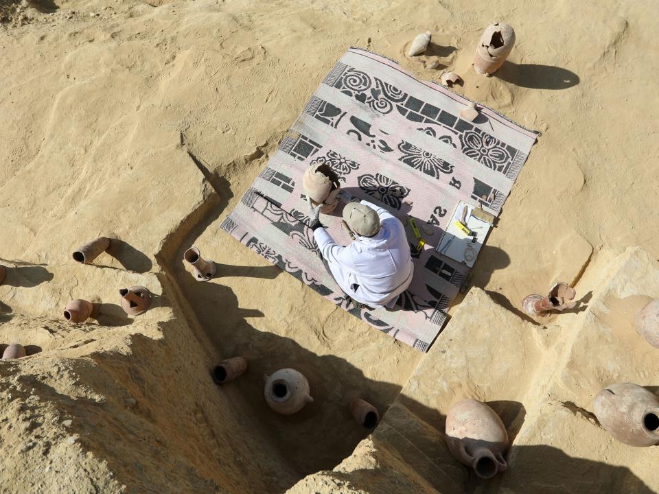 An archaeologist restores antiquities after the announcement of new discoveries in Saqqara.