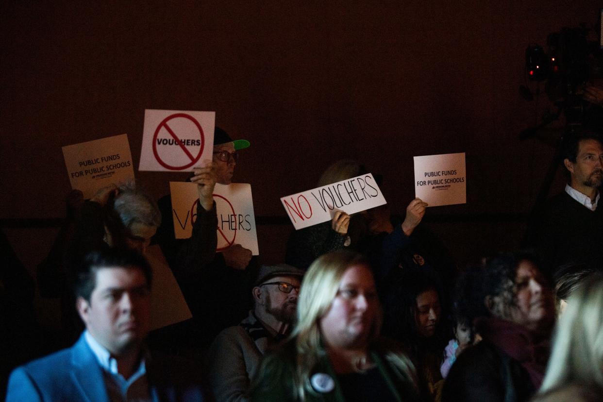 A group from Americans United silently protest Gov. Bill Lee’s Education freedom proposal with signs “No Vouchers” at Tennessee State Museum in Nashville, Tenn., Tuesday, Nov. 28, 2023.
