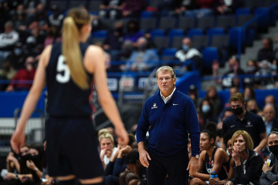 UConn head coach Geno Auriemma (right) looks at Huskies point guard Paige Bueckers.