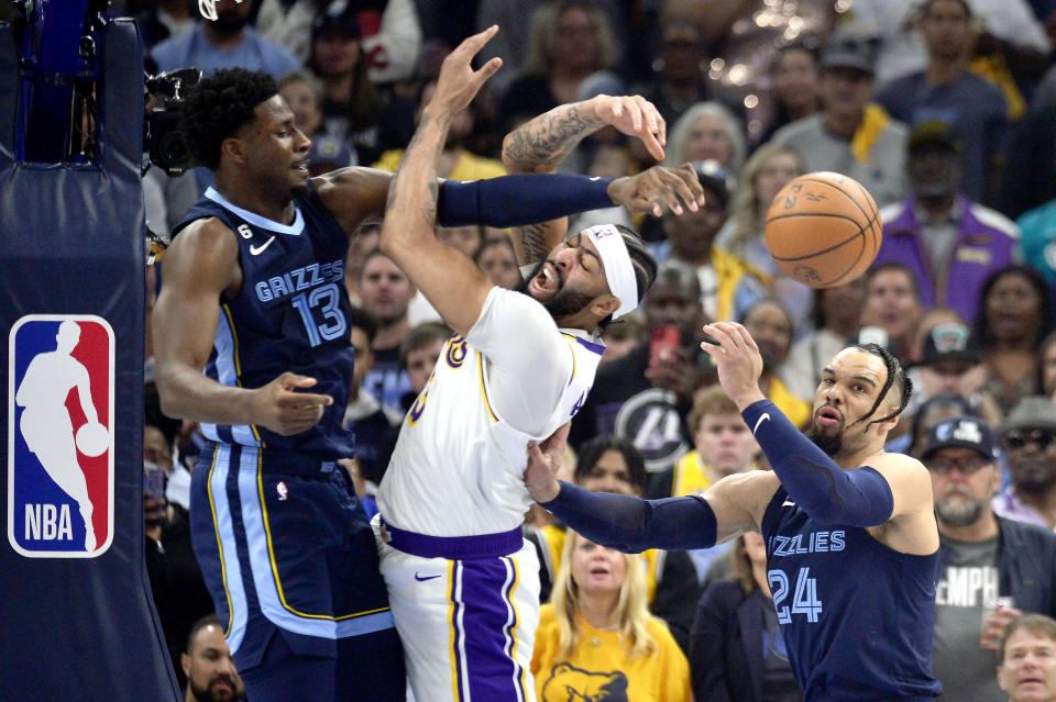 Los Angeles Lakers forward Anthony Davis (3), center, loses control of the ball between Memphis Grizzlies forwards Jaren Jackson Jr. (13) and Dillon Brooks (24) during Game 1 of a first-round NBA basketball playoff series Sunday, April 16, 2023, in Memphis, Tenn. (AP Photo/Brandon Dill)