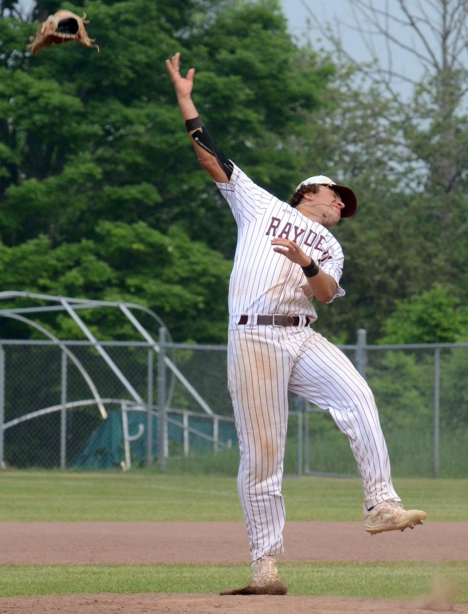 Charlevoix pitcher Bryce Johnson tosses his glove up in the air in celebration after the final out was recorded for the district title.