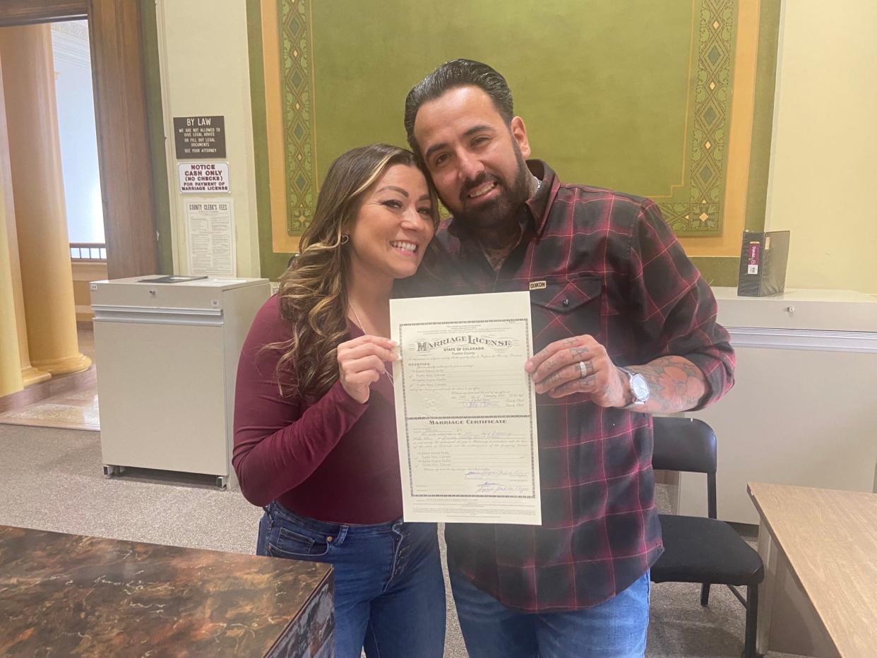 Sophia and Robert Derby hold up their marriage license at the Pueblo County Clerk and Recorder's Office
