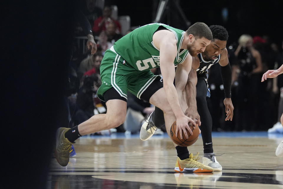 Boston Celtics guard Svi Mykhailiuk (50) and Atlanta Hawks guard Wesley Matthews (32) battle for a loose ball during the first half of an NBA basketball game Monday, March 25, 2024, in Atlanta. (AP Photo/John Bazemore)