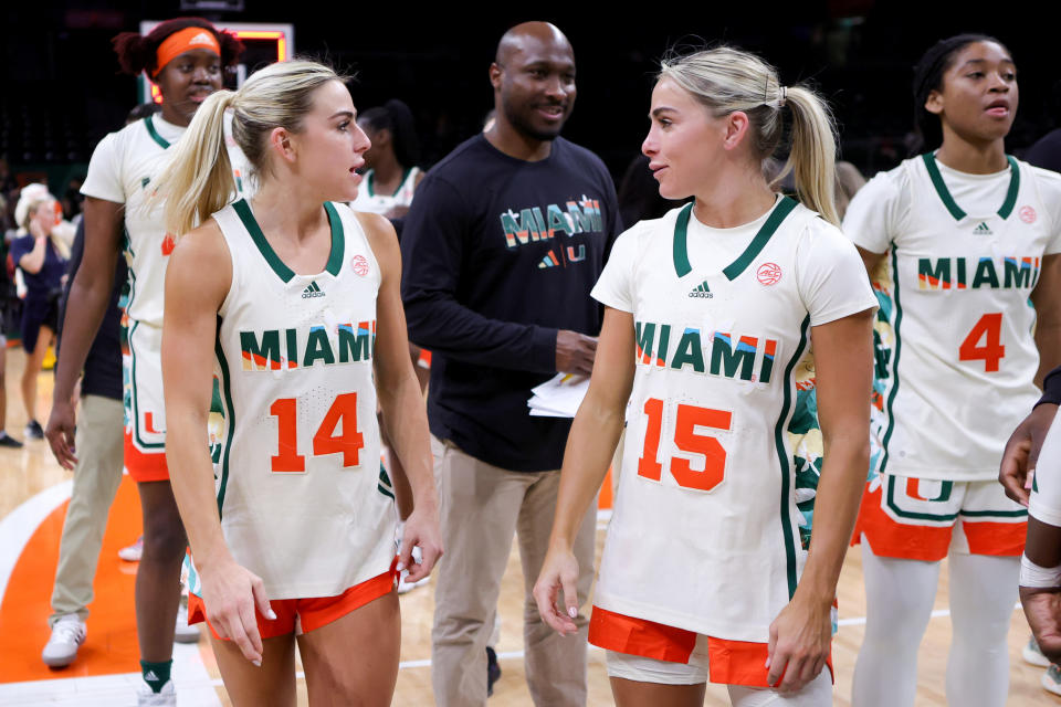 CORAL GABLES, FLORIDA - FEBRUARY 16: Haley Cavinder #14 and Hanna Cavinder #15 of the Miami Hurricanes talk on the court after defeating the Clemson Tigers at Watsco Center on February 16, 2023 in Coral Gables, Florida. (Photo by Megan Briggs/Getty Images)