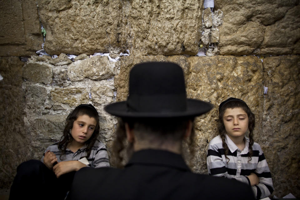 <p>Ultra-Orthodox Jewish men pray as they gather for the mourning ritual of Tisha B’Av at the Western Wall, the holiest site where Jews can pray, in Jerusalem’s Old City, July 29, 2012. (Photo: Oded Balilty/AP) </p>