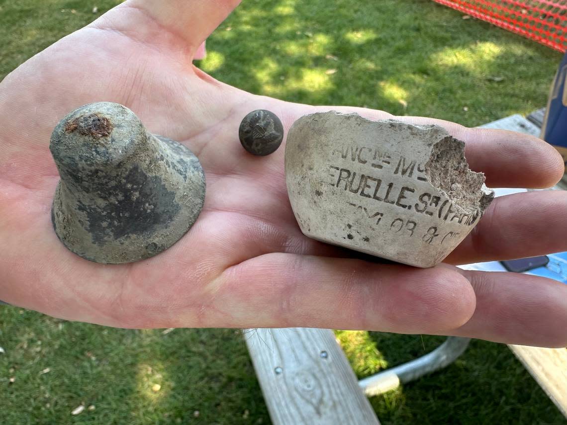 Chris Shaver, archaeologist for the Idaho State Historic Preservation Office, holds some of the smaller items found at the construction site around the Assay Office building.