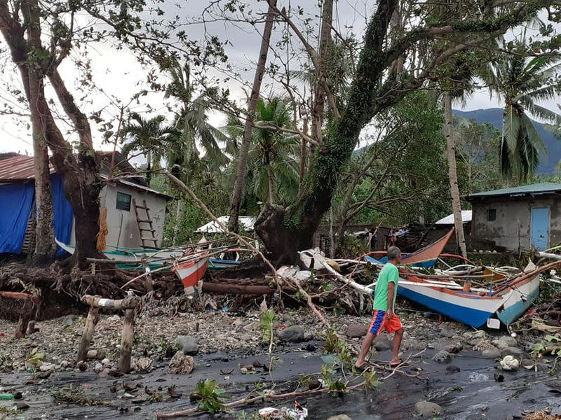 A man walks past storm debris in Biliran