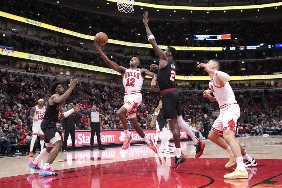 Chicago Bulls' Ayo Dosunmu (12) drives to the basket past Portland Trail Blazers' Deandre Ayton (2) during the second half of an NBA basketball game Monday, March 18, 2024, in Chicago. (AP Photo/Charles Rex Arbogast)