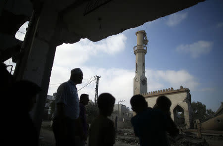 Palestinians look at the remains of a mosque, which witnesses said was hit by an Israeli air strike, in Beit Hanoun in the northern Gaza Strip August 25, 2014. REUTERS/Mohammed Salem