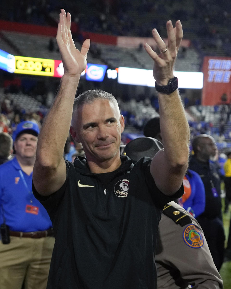 Florida State coach Mike Norvell celebrates with fans as he leaves the field after the team's win over Florida in an NCAA college football game Saturday, Nov. 25, 2023, in Gainesville, Fla. (AP Photo/John Raoux)