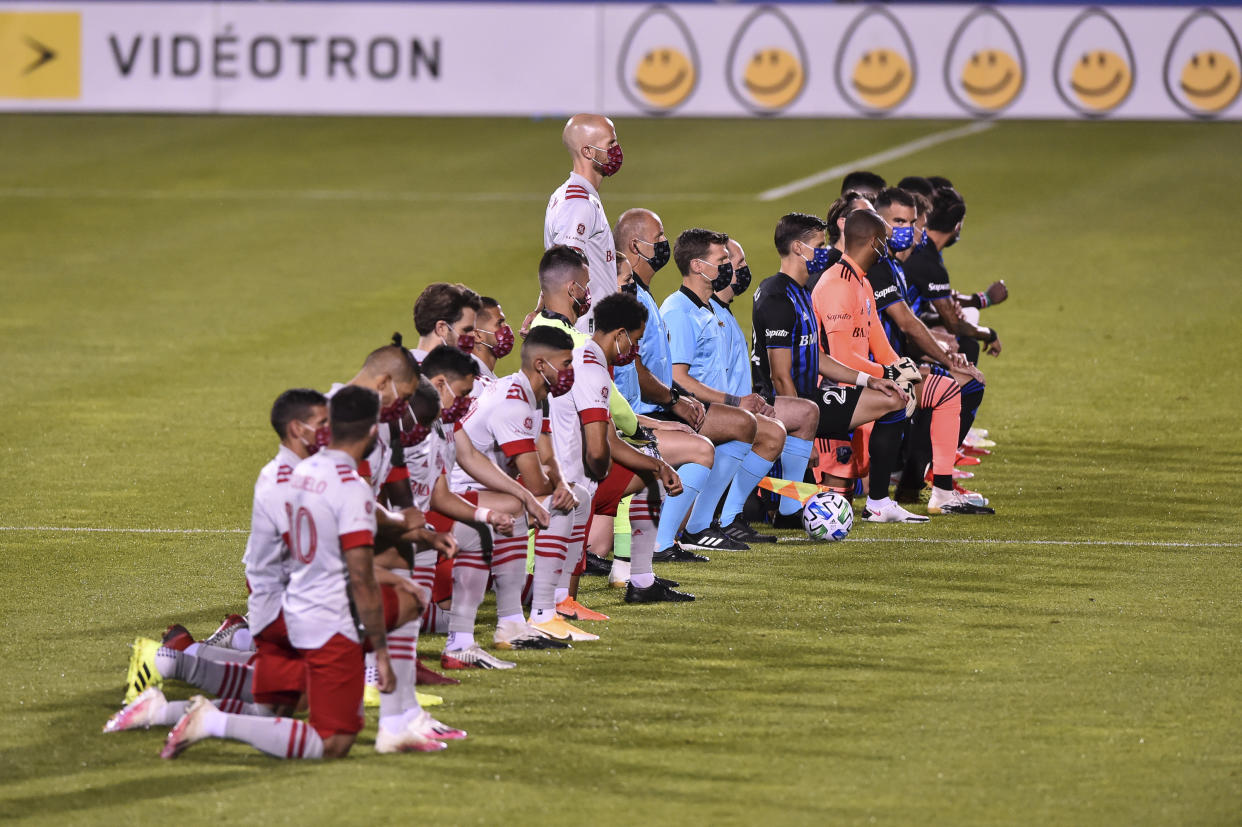 MONTREAL, QC - AUGUST 28:  Michael Bradley #4 of Toronto FC stands while his teammates and members of the Montreal Impact kneel during the pre-game ceremony of the MLS game at Saputo Stadium on August 28, 2020 in Montreal, Canada. (Photo by Minas Panagiotakis/Getty Images)