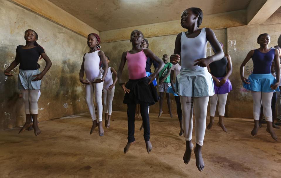 In this photo taken Friday, Dec. 9, 2016, young ballerinas practice under the instruction of Kenyan ballet dancer Joel Kioko, 16, in a room at a school in the Kibera slum of Nairobi, Kenya. In a country not usually associated with classical ballet, Kenya's most promising young ballet dancer Joel Kioko has come home for Christmas from his training in the United States, to dance a solo in The Nutcracker and teach holiday classes to aspiring dancers in Kibera, the Kenyan capital's largest slum. (AP Photo/Ben Curtis)