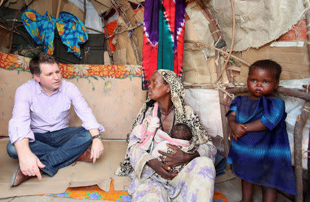 FILE PHOTO: Justin Forsyth, Chief Executive of Save the Children UK, talks to internally displaced Somalis at a camp in Hodan district of Somalia's capital Mogadishu, November 21, 2012. REUTERS/Feisal Omar/File Photo