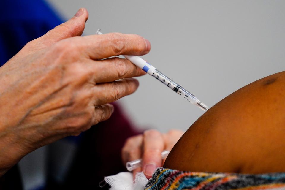 A health worker administers a dose of a COVID-19 vaccine during a vaccination clinic at the Keystone First Wellness Center in Chester, Pa., Wednesday, Dec. 15, 2021.