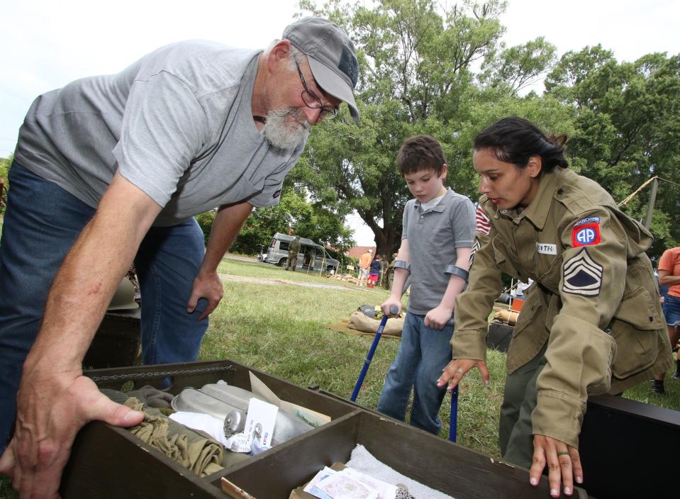 Eleven-year-old L.J. Sutton and his grandfather, Joseph Sutton, are showed a footlocker by Ana Maria Turner during Kings Mountain Historical Museum’s World War II Living History Day held Saturday, July 30, 2022, outside the museum on East Mountain Street in Kings Mountain.