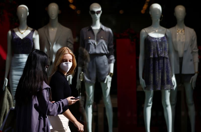 Pedestrians wearing protective face masks walk along Regent Street, amid the coronavirus disease (COVID-19) outbreak, in London