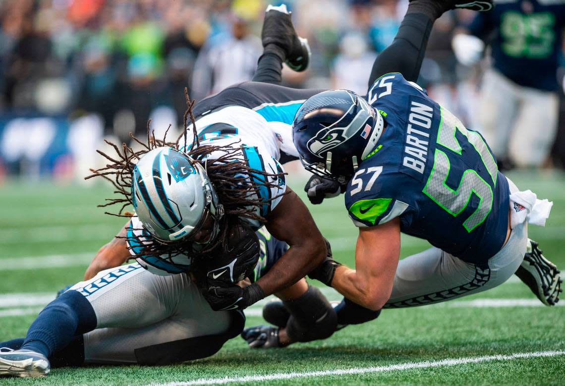 Seattle Seahawks linebacker Cody Barton (57) and Seattle Seahawks safety Ryan Neal (26) collide with Carolina Panthers tight end Ian Thomas (80) while trying to tackle Thomas in the first quarter of an NFL game at Lumen Field in Seattle Wash., on Dec. 11, 2022.