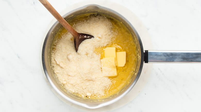 Polenta, butter and parmesan cheese in saucepan