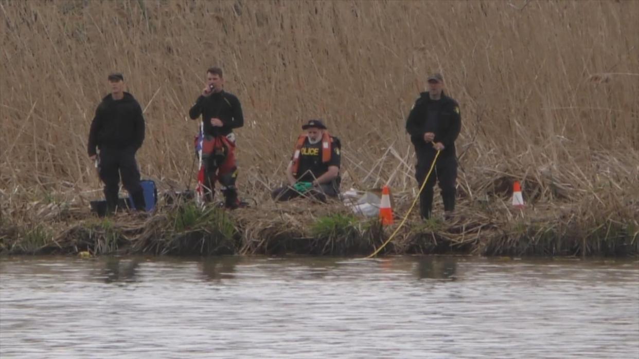 Police with the OPP's search and recovery unit were seen in Dunville, Ont., in 2022 with officers on a boat, on shore and in the water combing the river. (CBC News - image credit)