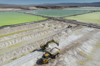 Heavy equipment collects lithium carbonate and salt at the SQM Lithium company facilities near Peine, Chile, Tuesday, April 18, 2023. Between 2021 and 2023, the price for one ton of lithium in U.S. markets nearly tripled, reaching a high of $46,000 a ton last year, according to a United States Geological Survey report. In China, the main customer of the region’s lithium, a ton of the metal went for a whopping $76,000 at its peak last year. (AP Photo/Rodrigo Abd)