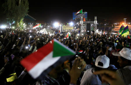 Sudanese demonstrators wave their national flags as they attend a mass anti-government protest outside the Defence Ministry in Khartoum, Sudan, April 21, 2019. REUTERS/Mohamed Nureldin Abdallah