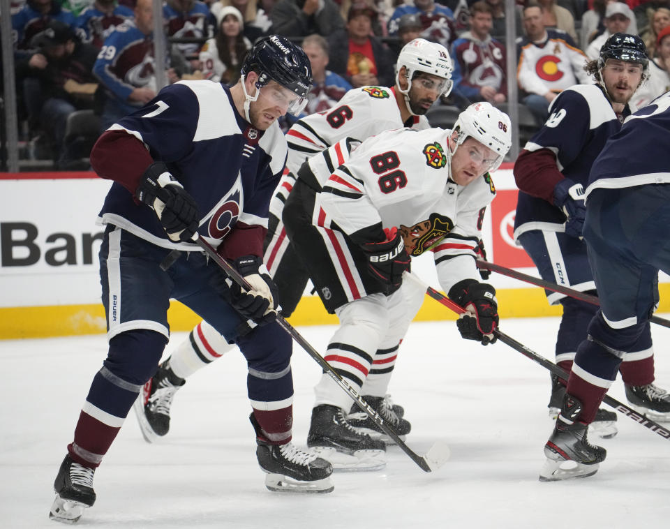 Colorado Avalanche defenseman Devon Toews, front, Chicago Blackhawks left wing Mike Hardman (86) and Blackhawks left wing Austin Wagner fight for control of the puck in the second period of an NHL hockey game Monday, March 20, 2023, in Denver. (AP Photo/David Zalubowski)