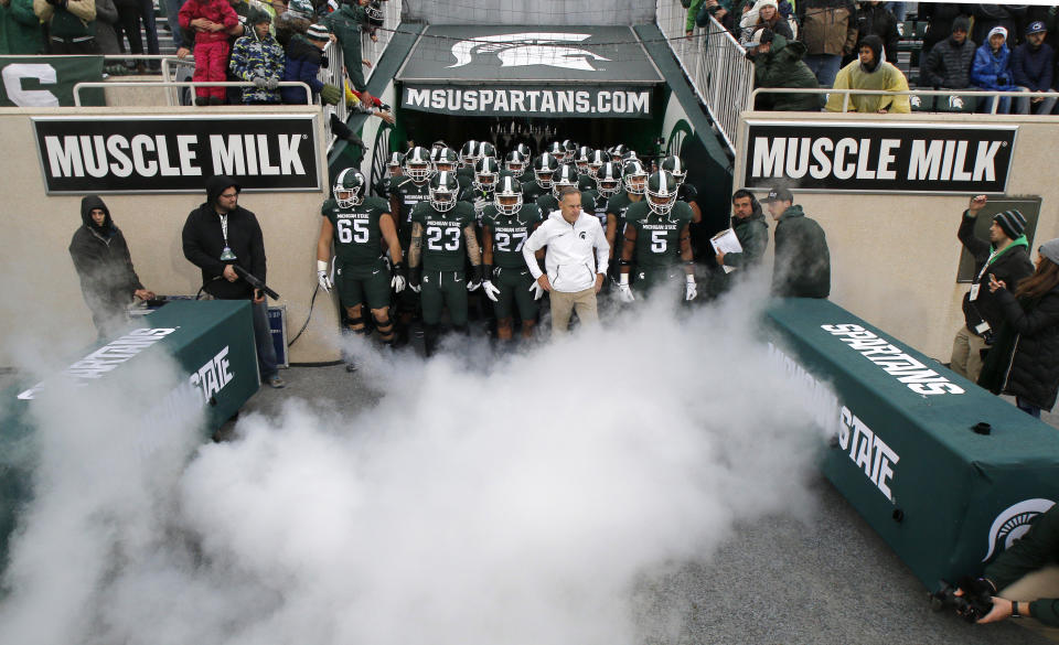 Michigan State coach Mark Dantonio, in white, and players prepare to take the field before an NCAA college football game against Penn State, Saturday, Nov. 4, 2017, in East Lansing, Mich. (AP Photo/Al Goldis)