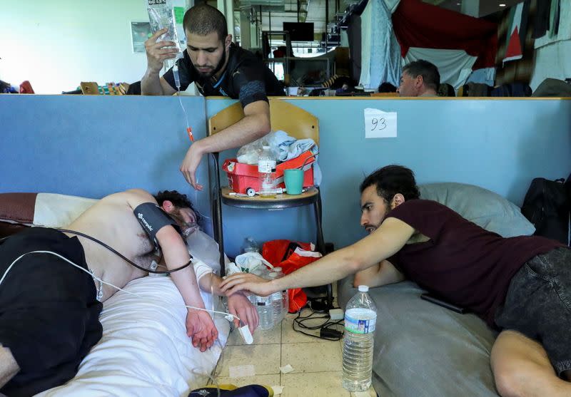 An asylum seeker is helped by people before being evacuated to a hospital, in Brussels