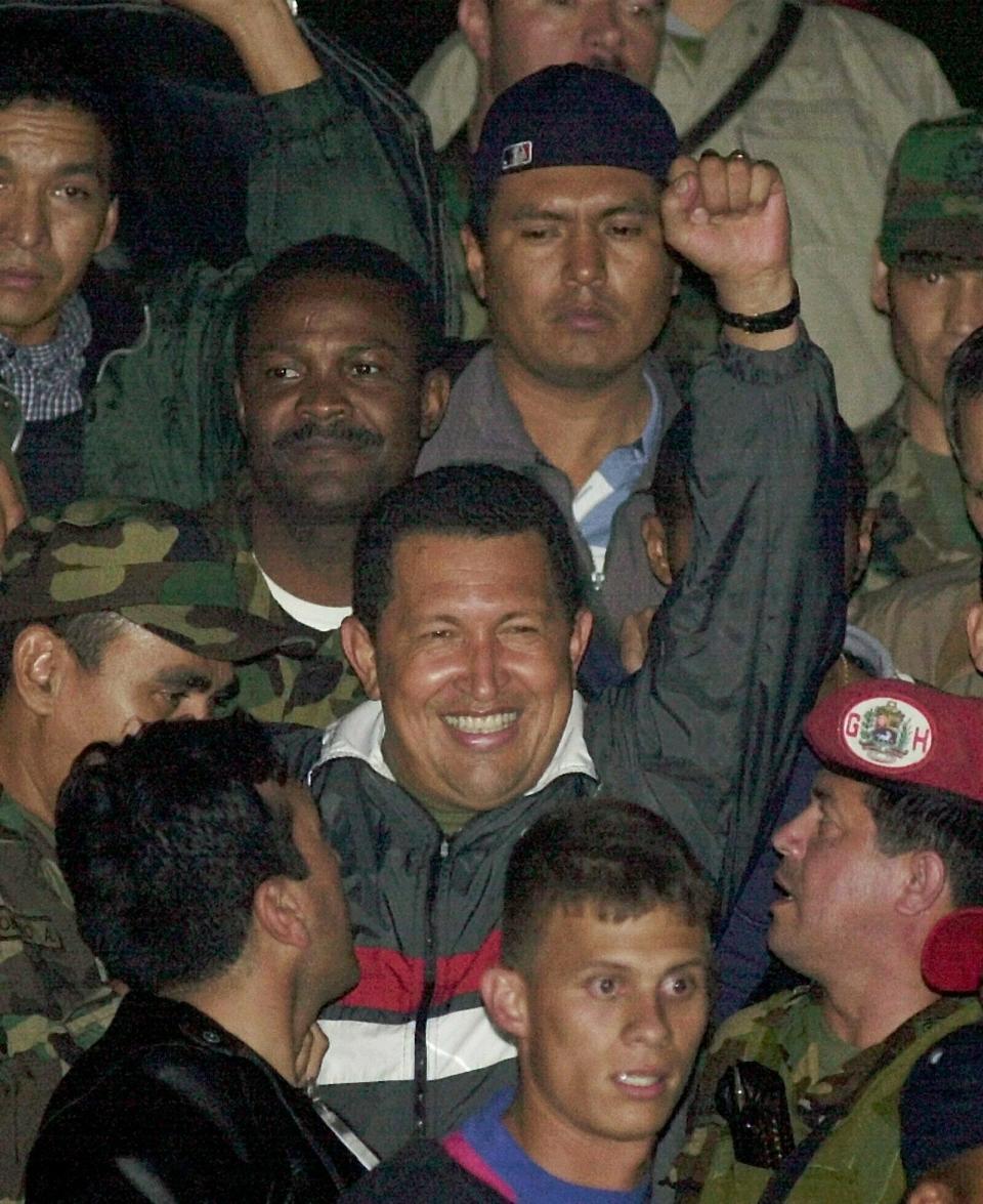 ARCHIVO - En esta fotografía del 14 de abril de 2002, el presidente venezolano Hugo Chávez saluda a sus simpatizantes mientras llega al Palacio de Miraflores luego de ser liberado por las fuerzas militares dos días después de que el Ejército anunció que había renunciado en Caracas. Chávez fue derrocado por dos días antes de recuperar el gobierno. Él y sus aliados acusaron a Estados Unidos de brindar apoyo tácito para el intento de golpe de Estado. (AP Foto/Dario Lopez-Mills, Archivo)